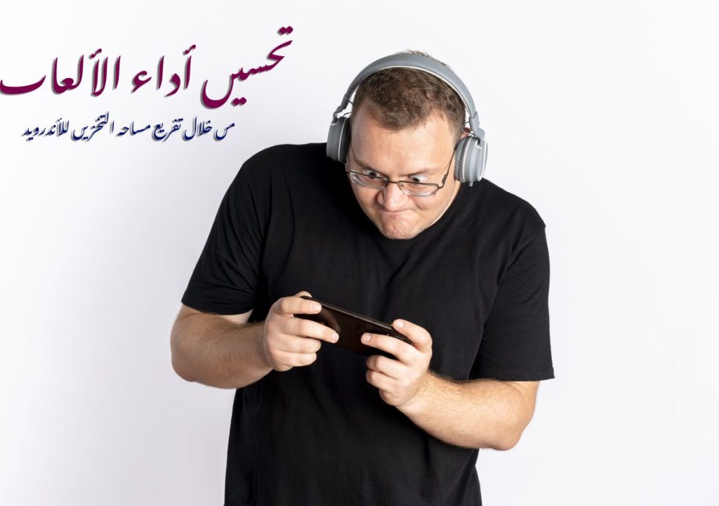 overweight man glasses wearing black t shirt with headphones playing game his smartphone standing white wall